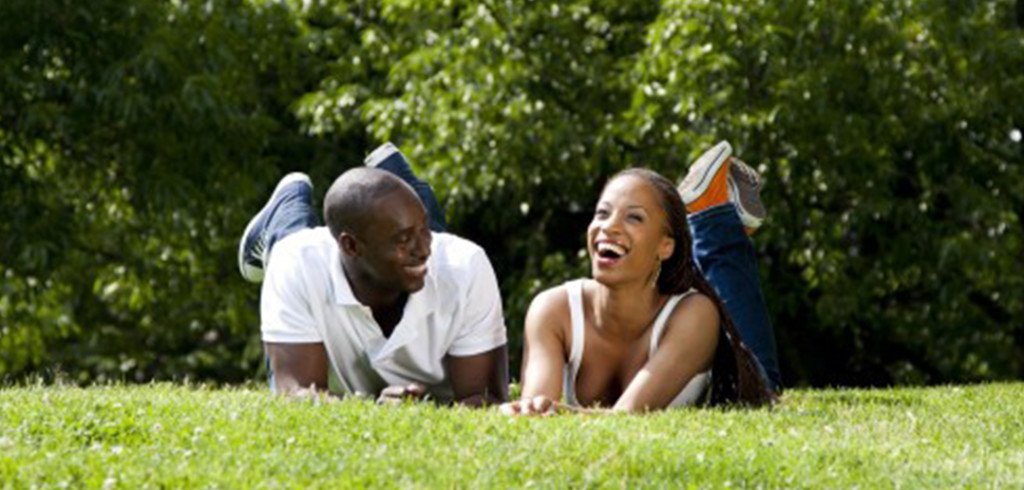 laughing black couple in grass